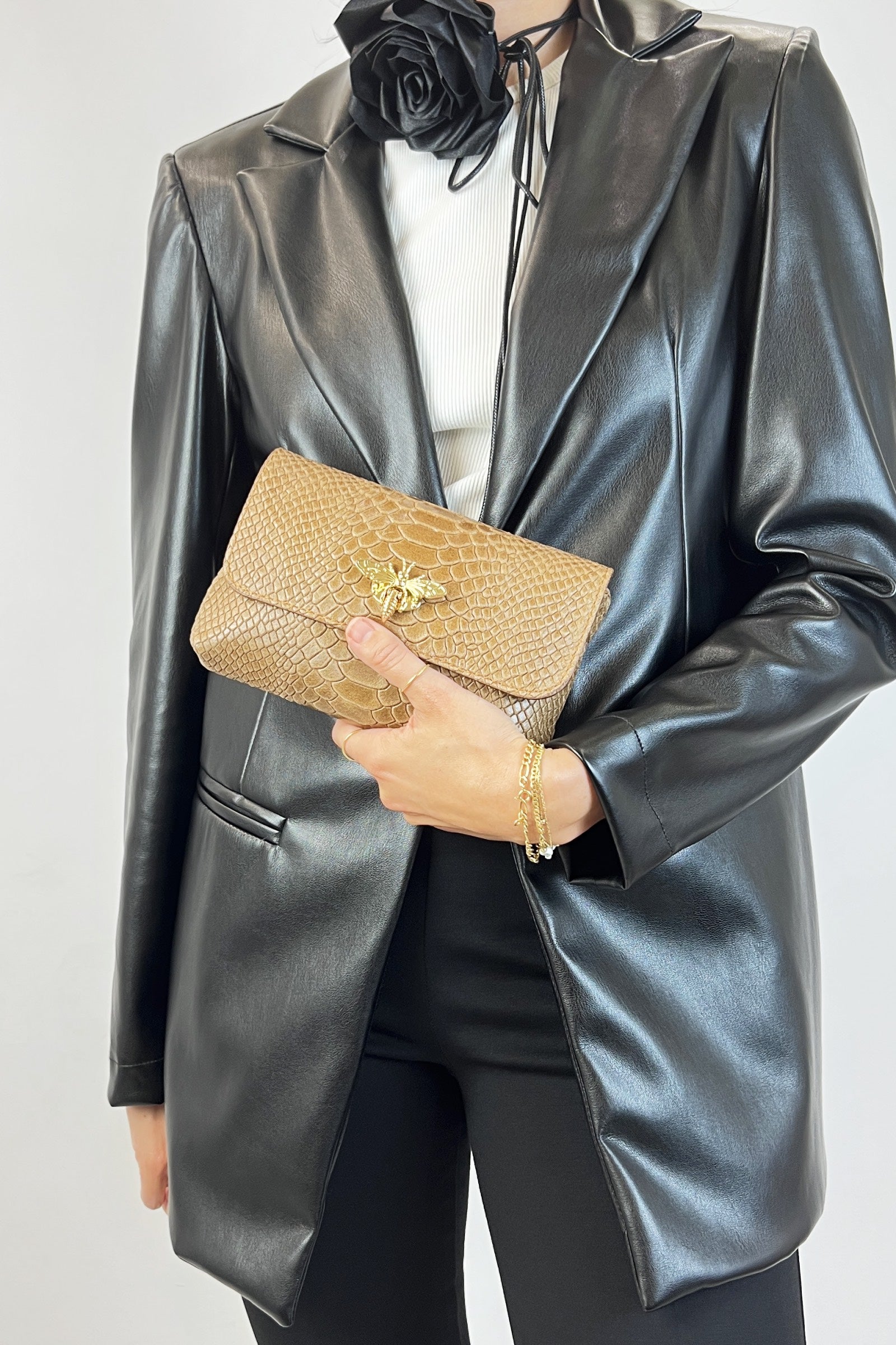 Borsa modello MARTA in pelle effetto pitonato con chiusura dorata a forma di ape, vista frontale, tenuta a mano