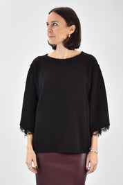 Foto indossata frontale di maglia girocollo con inserti in pizzo e manicotti in coordinato. Maglia di Haveone nera con maniche corte, pizzo e manicotti