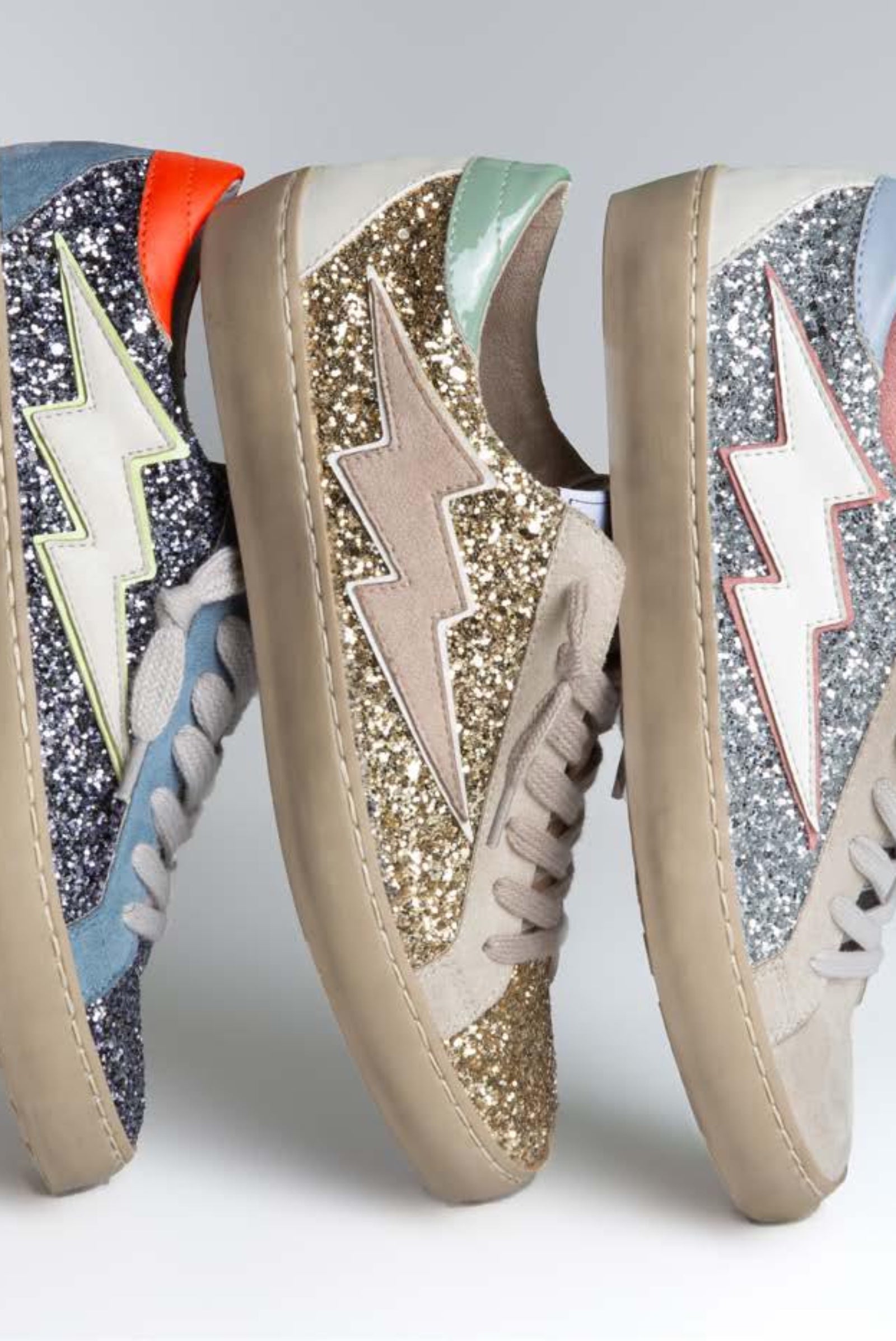 Sneaker bassa in ecocamoscio ricoperta da glitter oro, con patch fulmine sul lato esterno. Brand corina, calzata regolare, colore oro